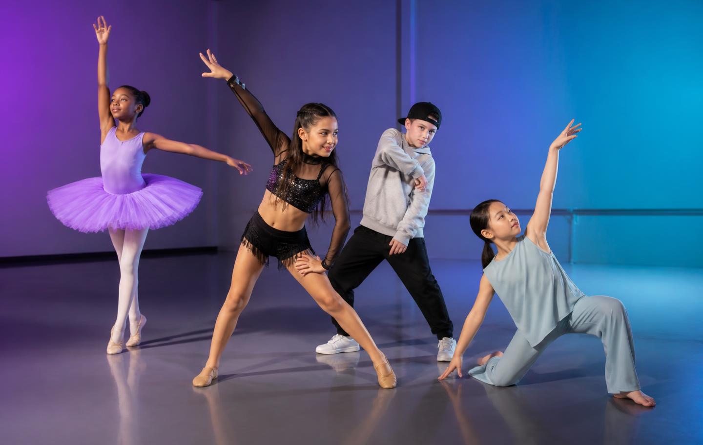 A diverse group of young dancers moving together in a lit studio